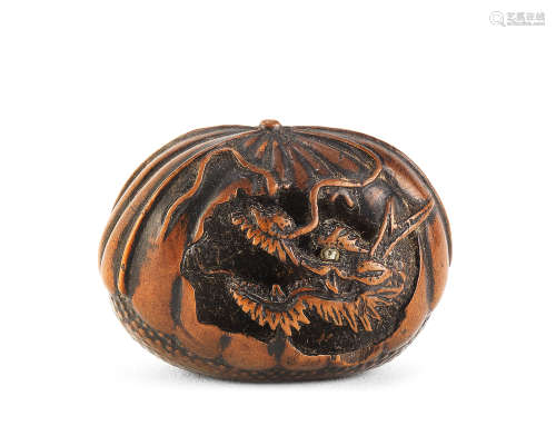 A wood netsuke of a dragon in a chestnut By Toyoyasu (Toyoyo...