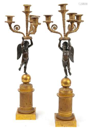 一对烛台斑驳的青铜和镀金的青铜，代表两个有翅膀的恋人，支撑着一...