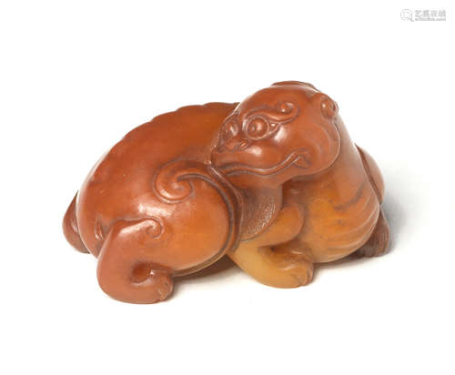 A FINE PALE GREEN AND RUSSET JADE CARVING OF A MYTHICAL BEAS...