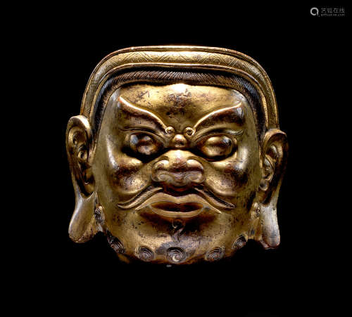 A RARE AND LARGE GILT-BRONZE HEAD OF A GUARDIAN Yuan/early M...
