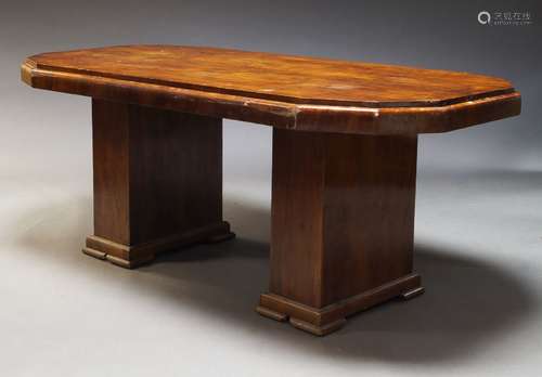 An Art Deco walnut dining table, the shaped top on rectangul...