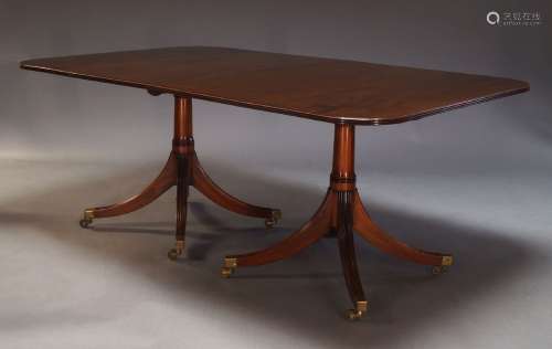 A George III style mahogany twin pedestal dining table, the ...