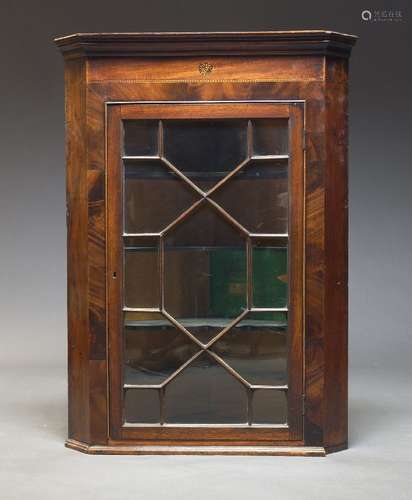 A George III mahogany and inlaid corner cupboard, with mould...