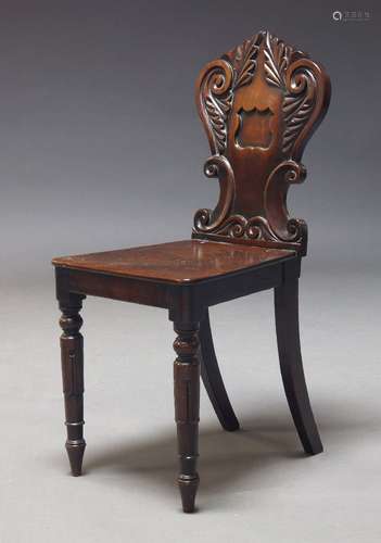 A Victorian mahogany hall chair, the shaped back carved with...