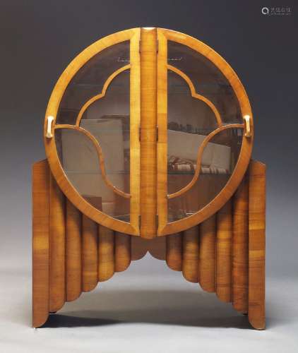 An English Art Deco walnut cabinet, of circular form having ...