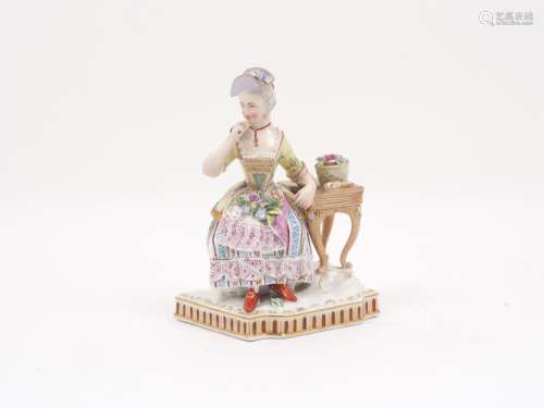 A Vienna porcelain figure in the form of a lady holding a po...