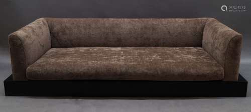 A contemporary low sofa, of recent manufacture, with brown u...