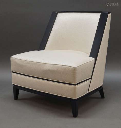 A contemporary cream upholstered and ebonised lounge chair, ...