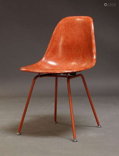 A red fibreglass shell chair, in the manner of Charles and R...