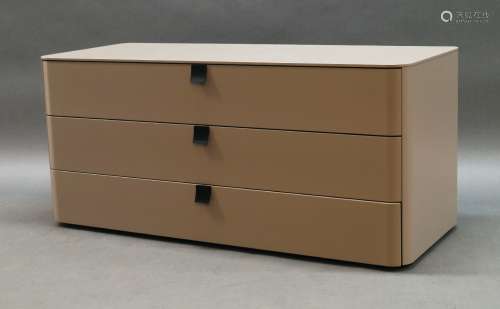 A contemporary grey lacquered chest of drawers, with rounded...