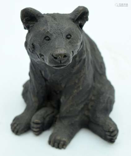 A CONTEMPORARY BRONZED FIGURE OF A BEAR modelled resting upo...