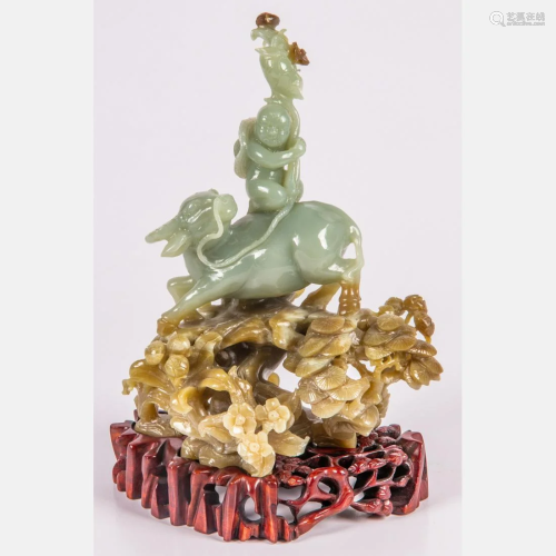 A Chinese Carved Jade Figure of a Boy Riding a Water