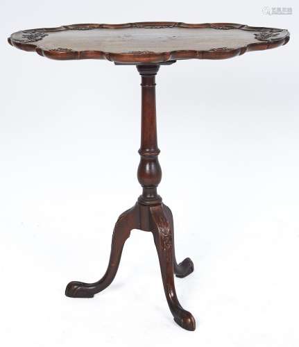 A carved mahogany tripod table, early 20th c, the shaped ova...