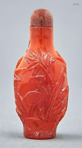 A Chinese amber snuff bottle, 20th c, carved with a bird and...