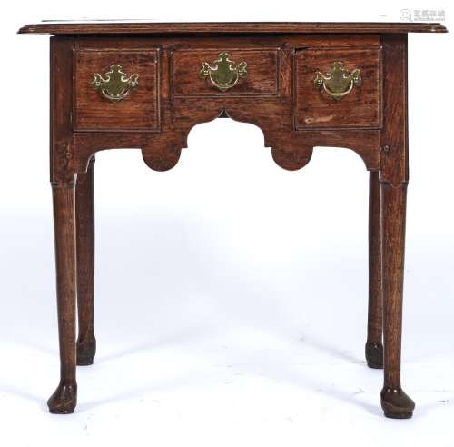 A George II oak lowboy, c1750, the top with rounded front co...