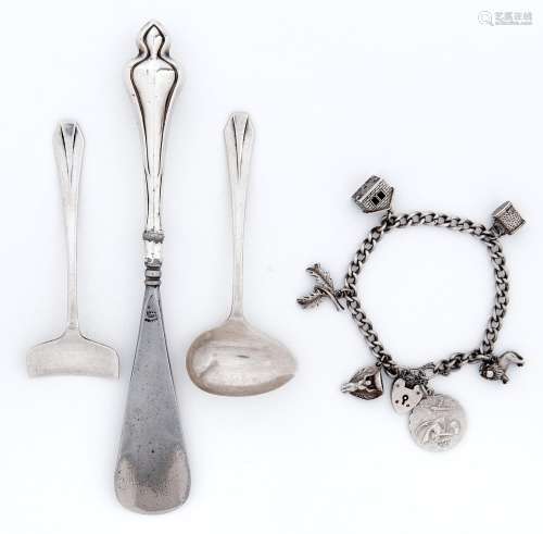 A silver charm bracelet, a silver child's spoon and pusher a...