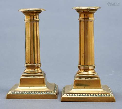 A pair of Victorian brass dwarf columnar candlesticks, on sq...