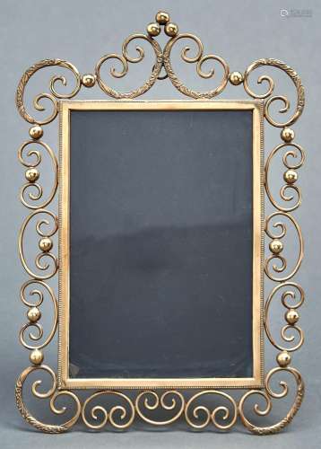 A brass photograph frame, c1905, of C scrolls and balls, rod...