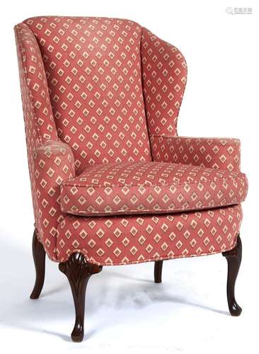 A George II style mahogany wing-back armchair on shell carve...