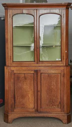 A large George IV oak standing corner cabinet, c1830, flared...