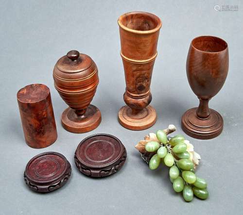 Treen. Three turned walnut goblets, one with cover and a yew...