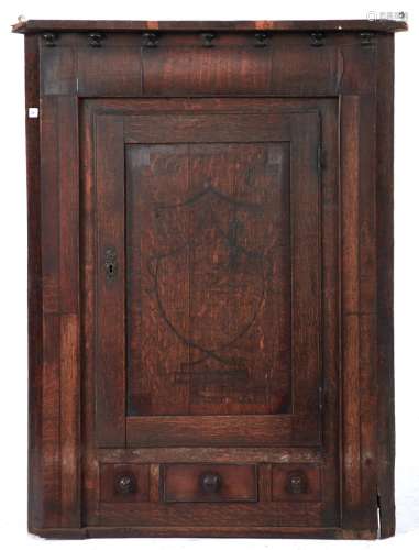 A George IV oak hanging corner cupboard, c1830, the rudiment...