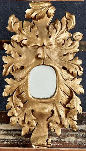 A carved oak mirror in the form of a grotesque mask, perhaps...