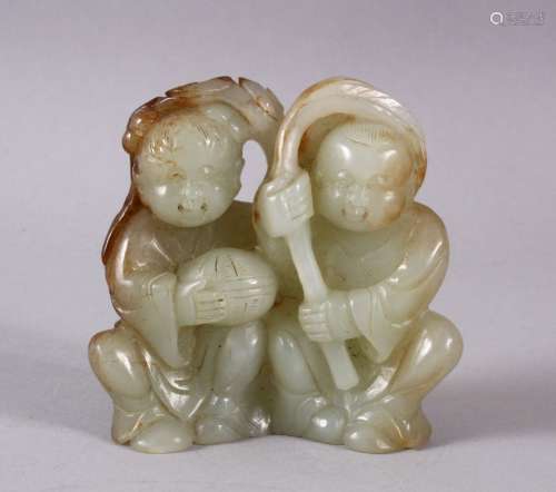 A CHINESE CARVED CELADON JADE FIGURE OF TWO BOYS, both seate...
