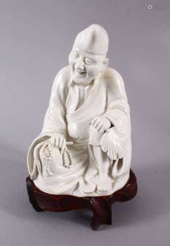 A CHINESE BLANC DE CHINE PORCELAIN FIGURE OF A SEATED SCHOLA...