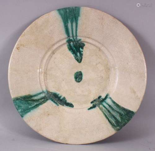 A 12TH CENTURY ABBASID POTTERY PLATE, with green drip decora...