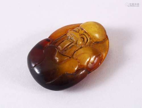 A CHINESE CARVED AMBER FIGURE OF SHOU LAO - carved in deep r...