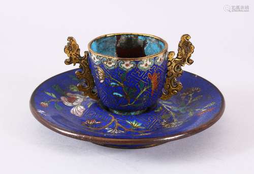 A CHINESE CLOISONNE TEA CUP AND SAUCER, upon a blue ground w...