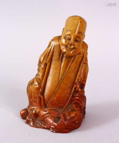 A CHINESE CARVED SOAPSTONE FIGURE OF A JOLLY MAN, in seated ...