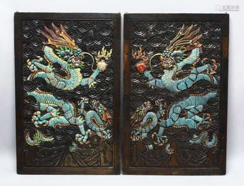 A PAIR OF CHINESE CARVED AND PAINTED HARDWOOD PANELS, depict...