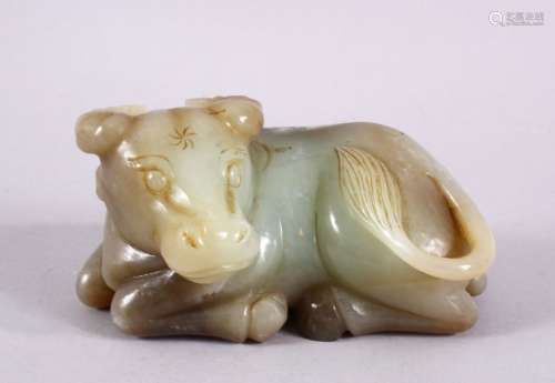 A CHINESE CARVED JADE FIGURE OF A RECUMBENT COW / OX, in a r...