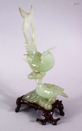 A CHINESE CARVED GREEN JADE FIGURE OF TWO BIRDS, both seated...