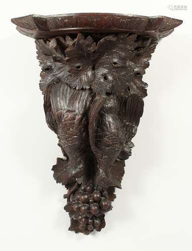 A BLACK FOREST CARVED WOOD WALL BRACKET, game, grapes and le...