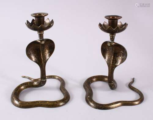 A PAIR OF INDIAN COBRA SNAKE FORMED CANDLE STICKS, the stick...