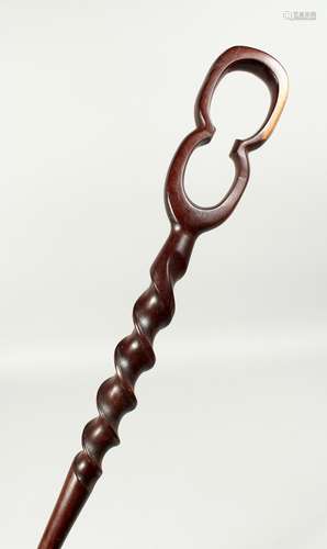 AN ETHNIC WOODEN WALKING STICK 38ins long.