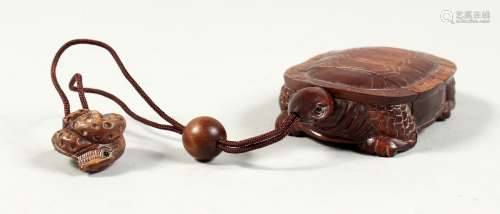 A CARVED WOODEN TURTLE INRO on a rope.