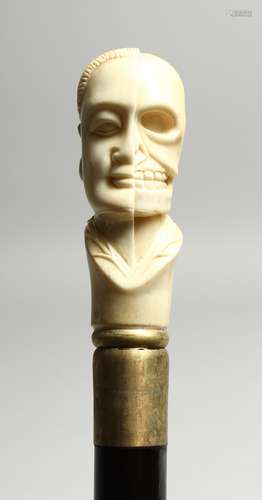 A BONE WALKING STICK 'HALF FACE, HALF SKULL' 35ins high