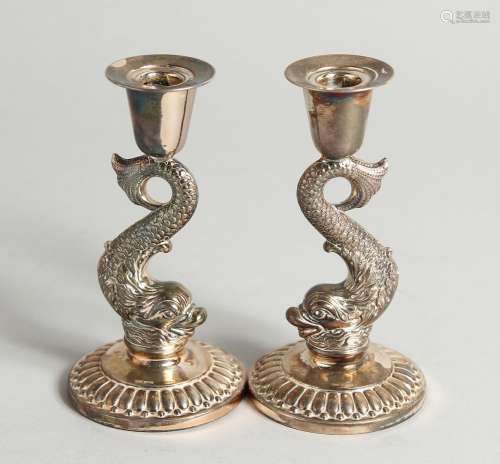 A PAIR OF SILVER DOLPHIN CANDLESTICKS 4ins high.