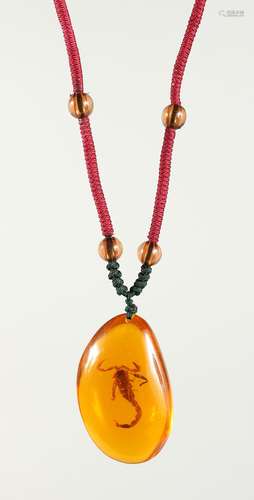 AN AMBER PENDANT inset with a bug on a rope