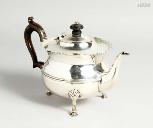 A CIRCUALR SILVER TEA POT with waved rim and wooden handles....