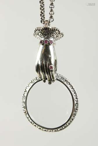 A RUBY SET HAND ENGRAVED MAGNIFYING GLASS on a chain.