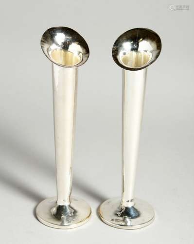 A PAIR OF SILVER FLOWER VASES on loaded circular bases. 7.5i...