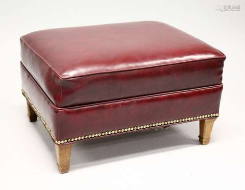 A RED LEATHER UPHOLSTERED FOOTSTOOL, on tapering square legs...