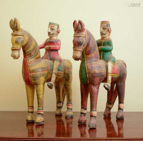 A pair of carved wooden horses and riders,
