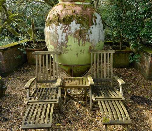 A pair of teak and brass reclining steamer lounge chairs,