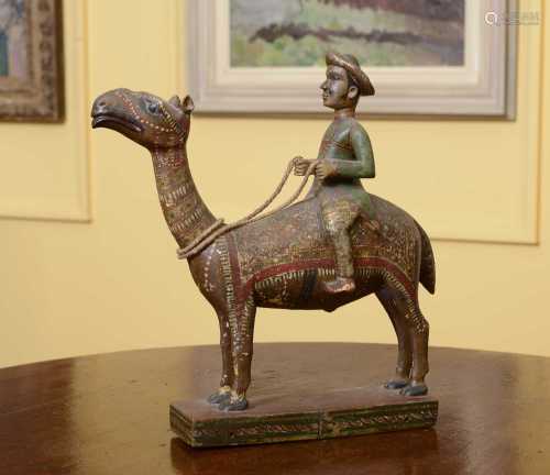 A carved wooden and polychromed figure of a gentleman riding...